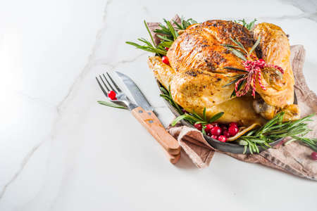 Traditional Christmas and Thanksgiving roasted whole chicken with fruit and rosemary. White marble...