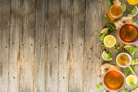 Autumn tea with mint and lemon with ingredients - fresh mint leaves, sliced lemon and honey, rustic wooden background copy spaceの写真素材