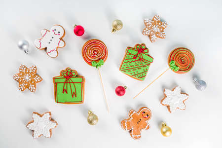 Homemade christmas sugar and gingerbread cookies decorated with colorful icing on white background...