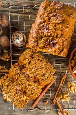 Homemade carrot cake with walnuts, rustic wooden background with ingredients, copy spaceの写真素材