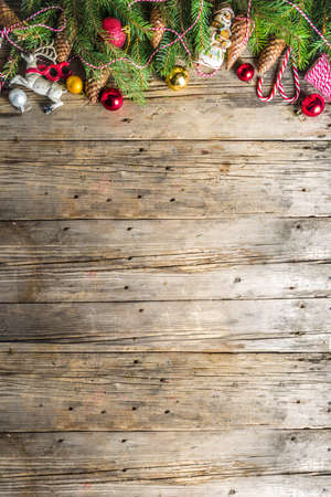 Christmas greeting background with Christmas tree branches, traditional decorations, gifts and xmas balls. Classic wooden background, top view flat lay copy spaceの写真素材