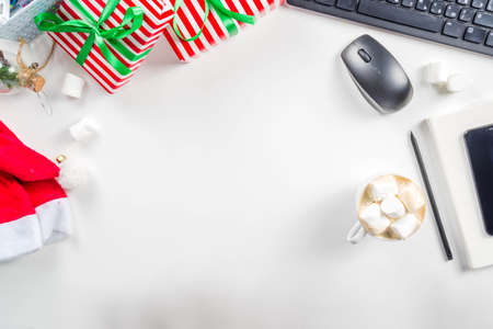 Office secret santa concept with Office table surface, keyboard, mouse, gift boxes and Christmas decoration whiteの写真素材
