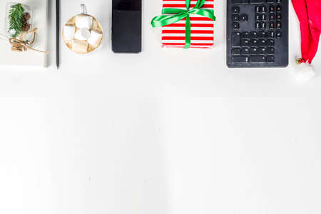 Office secret santa concept with Office table surface, keyboard, mouse, gift boxes and Christmas decoration whiteの写真素材