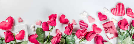 Valentines Day background with handmade red textile hearts,red ribbon and roses. White background  flay lay pattern top view copy spaceの写真素材