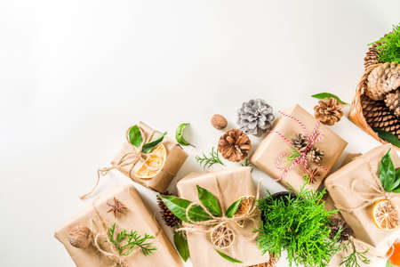 Zero waste christmas concept. Stack of handmade christmas gift boxes in craft paper with  different organic decoration and little live xmas tree in flowerpots.の写真素材