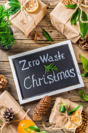 Zero waste christmas concept. Stack of handmade christmas gift boxes in craft paper with  different organic decoration and little live xmas tree in flowerpots.の写真素材