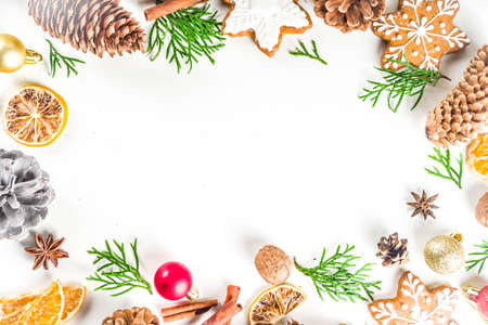 Christmas festive background with xmas fir tree branches, pine cones and decorations on white.