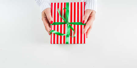 Female hands hold xmas gift boxes, champagne and glasses , white background with copy space....