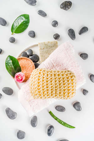 Bodycare organic cosmetics. Spa setting with basic hygiene treatment - sea salt, washcloth and natural handmade soap, and bath stuff ready for use. Zero waste bath care concept. White stone backgroundの写真素材