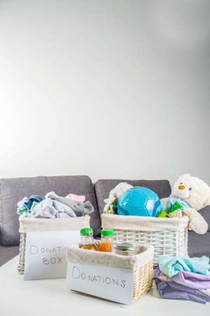 Giving and helping concept. Reuse and recycling theme. Donation box with clothes, children's toys, food. On a white backgroundの写真素材