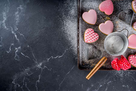 Valentine day greeting background. Valentine pink glazed heart  cookies with  red rose flowers on...
