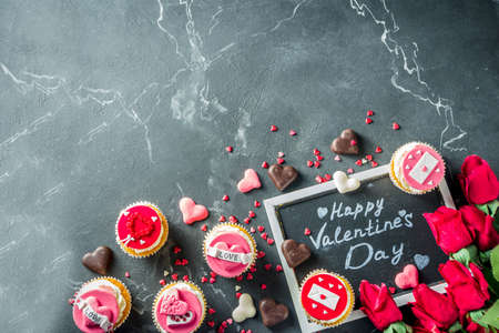 Valentine's day greeting card. Sweet Valentine's creative dessert food. Homemade pink and red  delicious cupcakes with decor of Valentine day symbolsの写真素材