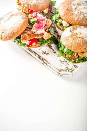 Various seafood and fish burgers assortment. Homemade healthy burger with grilled prawn, salmon, tuna, sea bass, fresh herbs, mozzarella cheese and baby spinach.の写真素材