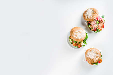 Various seafood and fish burgers assortment. Homemade healthy burger with grilled prawn, salmon, tuna, sea bass, fresh herbs, mozzarella cheese and baby spinach.の写真素材