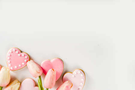 Homemade pick sugar glazed Valentine day cookies. Valentine heart shaped bakings. White stone background copy space top viewの写真素材