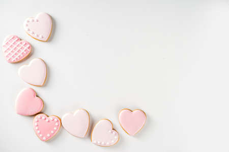Homemade pick sugar glazed Valentine day cookies. Valentine heart shaped bakings. White stone background copy space top viewの写真素材