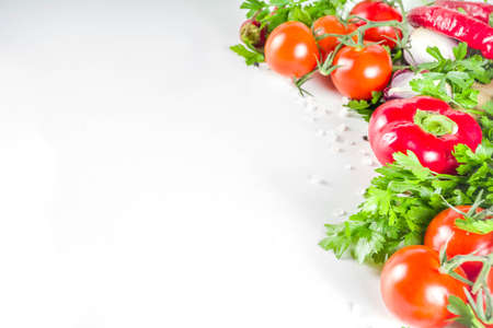 Cooking background with fresh vegetables and herbs. Healthy clean eating vegetarian food, diet nutrition concept. Various fresh veggie ingredients for salad or stew, white table, top view copy spaceの写真素材