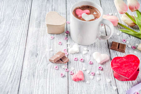 Valentines day treat ideas, two cups hot chocolate drink with marshmallow hearts red pink white color with chocolate pieces, sugar sprinkles, old wooden background copy space top viewの写真素材