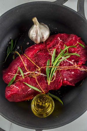 Raw beef tenderloin meat steak, with spices on a black cast iron skillet. Cooking food background.の写真素材