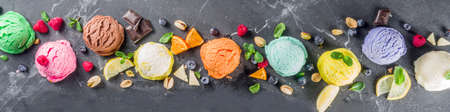 Colorful pastel ice cream with waffle cones and various flavor ingredients, black marble background,...