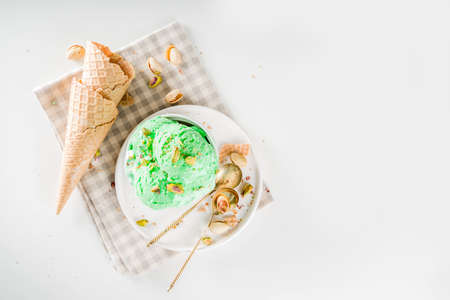 Pistachio ice cream with nuts in white bowlの写真素材