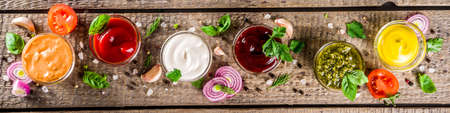 Set of sauces in small bowls - ketchup, mayonnaise, mustard, bbq sauce, pesto, classic burger sauce,...