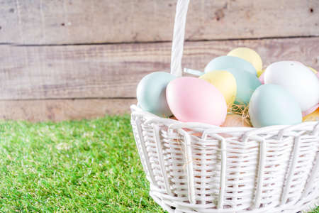 Colorful pastel Easter eggs on green and wooden garden terrace.  Funny spring decoration. Happy Easter greeting card background.の写真素材