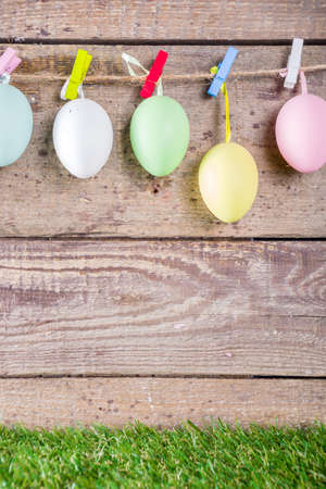 Colorful pastel Easter eggs on green and wooden garden terrace.  Funny spring decoration. Happy...