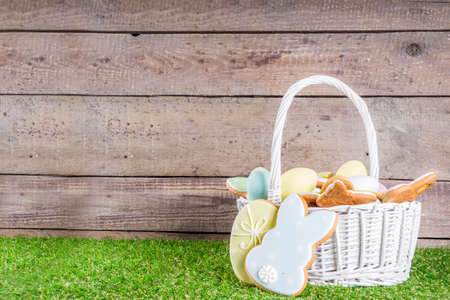 Sweet Easter baking cooking background with traditional Easter bunny and egg cookies, sugar sprinkles, Spring green grass background copy space layoutの写真素材