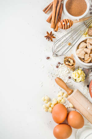 Ingredients for autumn winter festive baking - flour, brown sugar, eggs, chocolate drops, butter, cinnamon on white stone or concrete background.Top view copy space.の写真素材