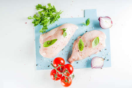 Raw chicken fillet with spices and herbs on cutting board. Cooking chicken breast background. Preparation food, Diet healthy meat.の写真素材