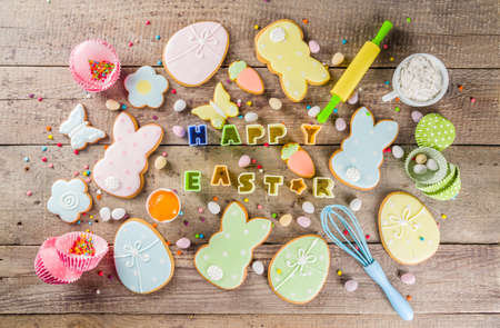Happy easter background with pastel colored easter cookies - bunnies, eggs, flower, butterfly,...