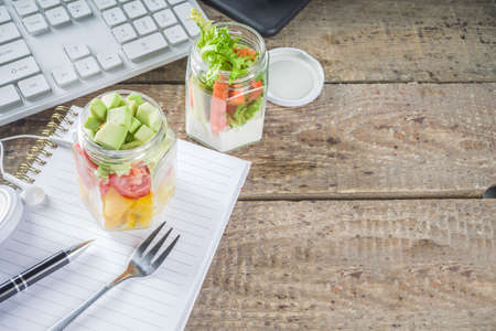 Healthy take-awayOffice lunch. Vegan vegetable salad in glass jars, with sliced fresh vegetables. Detox, raw eating and zero waste lunch concept.の写真素材