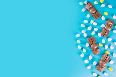 Easter composition with chocolate eggs and bunny rabbits, flat lay copy space