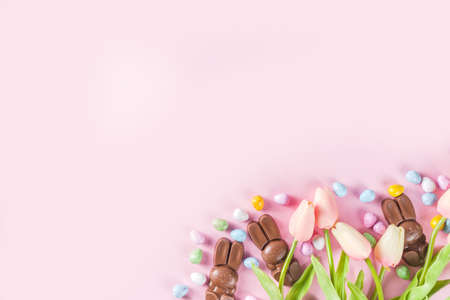 Easter composition with chocolate eggs and bunny rabbits, flat lay copy spaceの写真素材