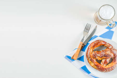 Oktoberfest festive cutlery set  with with a traditional checkered  tablecloth, plate, pretzel,...