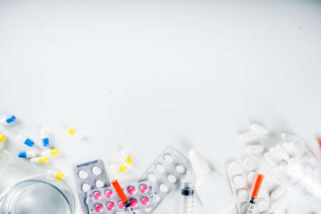 Pharmaceutical medicine pills concept, Assorted various pills, tablets and capsules with medical syringes, thermometer and water glass, copy space mockup, flatlayの写真素材