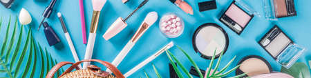 Professional makeup cosmetic set, with summer tropical leaves, woman bag. Make up items. luxury decorative cosmetics flatlay, top view, mockup. Beauty blogger concept. Trendy turquoise backgroundの写真素材