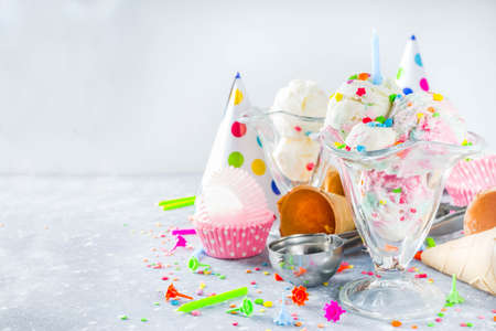Colorful Birthday cake ice cream with Birthday decoration and ice cream waffle cones, white gray background copy spaceの写真素材