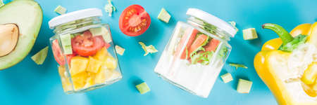 Healthy take-away lunch jar. Vegan vegetable salad in glass jars, with sliced fresh vegetables....