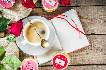 Valentine morning sweetheart scene. Breakfast on Valentine's Day February 14th. Sweet creative cupcakes with whipped cream and decor love, Valentine symbols. Mockup flatlay top view copy spaceの写真素材