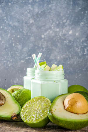 Avocado Milk Shake or Smoothie, Yogurt with Avocado and Lime Juice, with Fresh Avocados and limes on wooden background copy spaceの写真素材