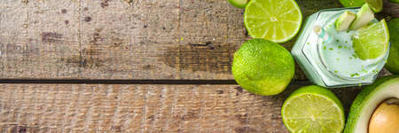 Avocado Milk Shake or Smoothie, Yogurt with Avocado and Lime Juice, with Fresh Avocados and limes on...