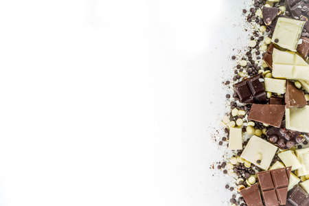 Assorted different types of chocolate. Broken pieces of dark, milk and white chocolate, with nuts,...