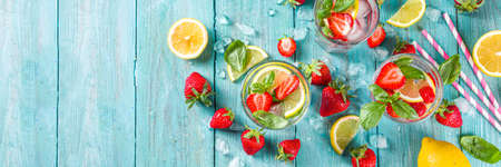 Strawberries and basil lemonade. Summer cold iced cocktail recipe, with fresh strawberry, lemon and basil leaves, wooden background copy spaceの写真素材
