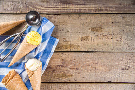 Set of various homemade colorful ice cream with icecream waffle cones on wooden background, copy...