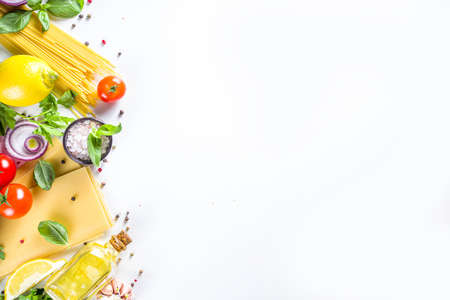 Italian food ingredients for  cooking Spaghetti Pasta. Raw spaghetti pasta with various ingredient - onion, tomatoes, garlic, basil, parsley, cheese, olive oil. On white table background, flatlay copy spaceの写真素材