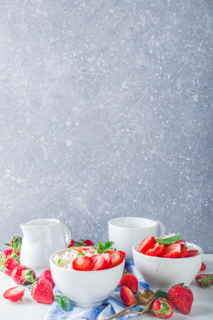 Summer morning rice pudding or rice porridge with strawberry and berry syrup in small bowl for, With milk and fresh strawberry copy spaceの写真素材