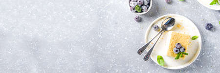 Homemade baked cake Napoleon, Millefeuille. Delicate custard cake garnished with berries and mint. On a gray concrete stone background.の写真素材