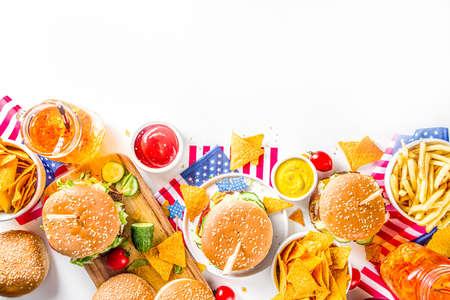 Celebrating Independence Day, July 4. Traditional American Memorial Day Patriotic Picnic with burgers, french fries and snacks, Summer USA picnic and bbq concept, White concrete backgroundの写真素材